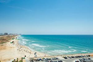 a beach with a lot of people and the ocean at Oceanus apartment hotel in Herzliya
