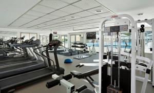a gym with treadmills and elliptical machines at Oceanus apartment hotel in Herzliya