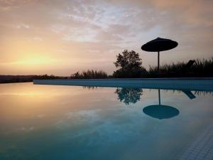una sombrilla sentada junto a una piscina en Dias Distintos - Turismo Rural en Colos