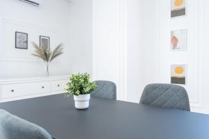 una sala da pranzo bianca con tavolo e sedie di Brioni Flat a Oradea