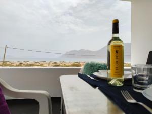 una bottiglia di vino seduta su un tavolo con un bicchiere di Beach View House a Famara