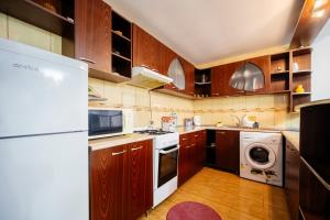 a kitchen with wooden cabinets and a white appliance at Casa Valeria Voronet in Voronet