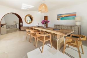a dining room with a wooden table and chairs at Villa Can Ravi in Cala de Bou
