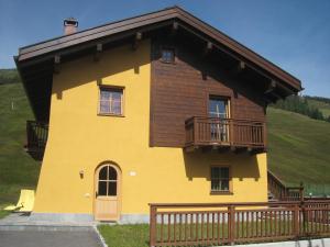 Casa amarilla con balcón en una colina en La Pezina, en Livigno
