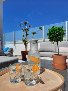 a glass vase and two glasses on a table at Sitius 5B - NEW seaview apartment with rooftop terrace in historical centre Sitio da Nazaré in Nazaré