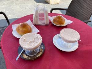 a red table with two drinks and donuts on it at B&B Duomo Pizzo ApartHotel in Pizzo