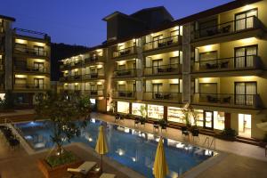 un hotel con piscina frente a un edificio en Deltin Suites en Candolim