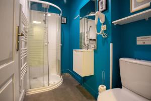 a blue bathroom with a shower and a toilet at Apartments WS Opéra-Folies Bergères in Paris