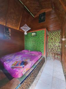 una piccola camera con letto viola di Lucky Bamboo'Bungalows-Resto and Orangutan Jungle Trekking Tours a Bukit Lawang