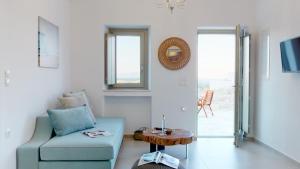 een woonkamer met een blauwe bank en een tafel bij ONAR RESIDENCE PAROS in Chrissi Akti