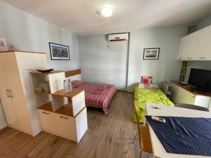 mały pokój z 2 łóżkami i telewizorem w obiekcie Enjoy Travel Cute Studio Apartment w Tiranie