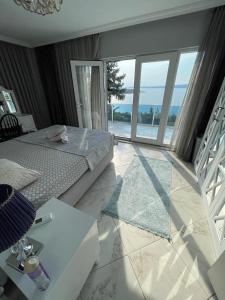 WHİTE ROSE VİLLA Jakuzili ve Isıtma Havuzlu في صبنجة: غرفة نوم مع سرير وإطلالة على المحيط