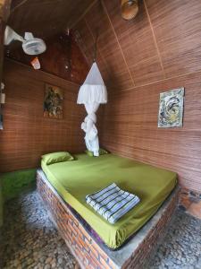 una camera con un letto con una lampada sopra di Lucky Bamboo'Bungalows-Resto and Orangutan Jungle Trekking Tours a Bukit Lawang