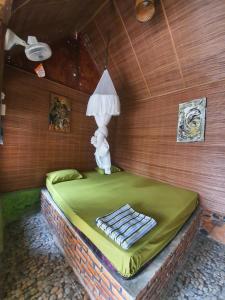a room with a bed with a lamp on it at Lucky Bamboo' Bungalows-Resto and OrangUtan Jungle Trekking Tours in Bukit Lawang