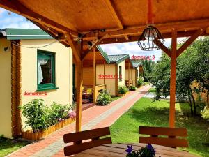 a patio with two benches in front of a house at Domki nad morzem w Sianożętach in Sianozety