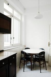 een eetkamer met een tafel en stoelen en een raam bij 13 Open House in Palermo