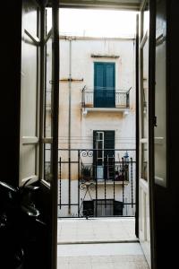 een open deur naar een balkon met een gebouw bij 13 Open House in Palermo