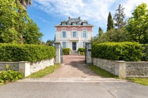 a pink and white house with a stone wall at Domaine de Bassilour in Bidart