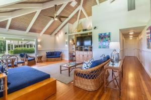 a living room with a blue couch and chairs at Makana Nui home in Hanalei