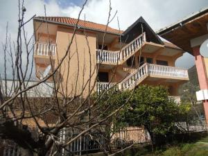 a large building with stairs and a house at Apartmani Dević Šušanj in Bar