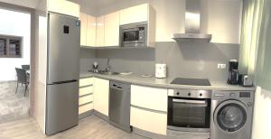 a kitchen with a refrigerator and a dishwasher at Apartamento La Cueva, Artenara in Artenara
