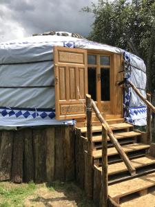 a yurt with a porch and a wooden fence at Eco Yourte Les Airelles in Saint-Anthème