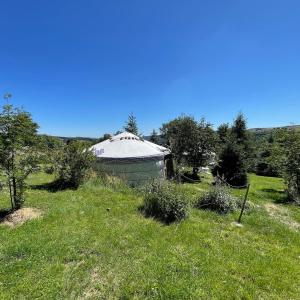 a large building in the middle of a field at Eco Yourte Les Airelles in Saint-Anthème