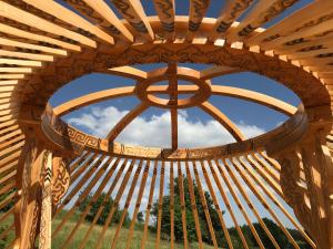 a window in a wooden archway with a sky at Eco Yourte Les Airelles in Saint-Anthème
