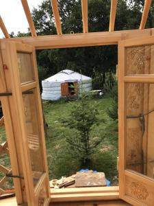 una ventana con vistas a una yurta desde una casa en Eco Yourte Les Airelles, en Saint-Anthème