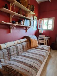 a bedroom with red walls and a bed with a blanket at Once Upon A Time in Rhodes Town