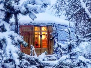 a cabin in the woods in the snow at Eco Yourte Les Airelles in Saint-Anthème