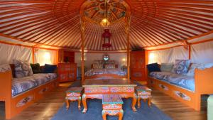 a bedroom with two beds and a table in a yurt at Eco Yourte Les Airelles in Saint-Anthème