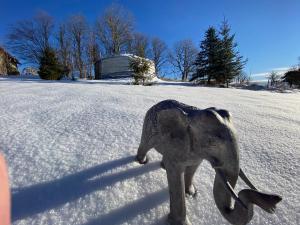 a statue of an elephant standing in the snow at Eco Yourte Les Airelles in Saint-Anthème