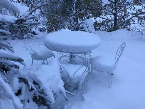a table and chairs covered in snow at Eco Yourte Les Airelles in Saint-Anthème