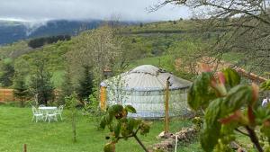 a yurt in the middle of a field with a table at Eco Yourte Les Airelles in Saint-Anthème