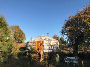 a dome house in a field with a table at Eco Yourte Les Airelles in Saint-Anthème
