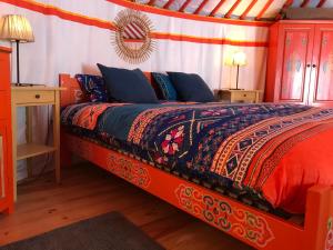 a bedroom with a bed and two night stands at Eco Yourte Les Airelles in Saint-Anthème