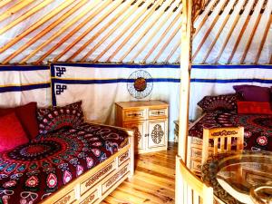 a room with two beds in a yurt at Eco Yourte Les Airelles in Saint-Anthème