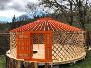 an orange gazebo sitting on top of a stump at Eco Yourte Les Airelles in Saint-Anthème