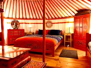 a bedroom with a canopy bed in a tent at Eco Yourte Les Airelles in Saint-Anthème