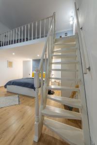 eine weiße Treppe in einem Schlafzimmer mit einem Bett in der Unterkunft Lovely 1 bedroom flat with central location in Budapest