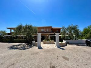 a house with a car parked in a driveway at Hotel Marina in Badesi