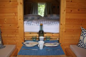 a table with a bottle of wine and glasses in a cabin at Schlaffässer Teichwiesenhof in Oldenburg in Holstein