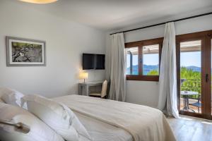 a bedroom with a bed and a window with a view at Hoposa Bahia in Port de Pollensa