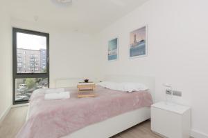 een witte slaapkamer met een groot bed en een raam bij Apartment Awanport Gdynia Żeromskiego by Renters in Gdynia
