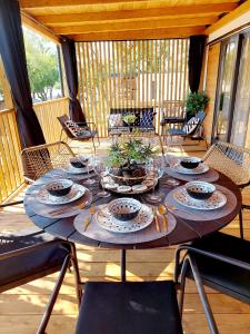 a wooden table with plates and dishes on a porch at Mobile Home Mar Vista Selce in Selce