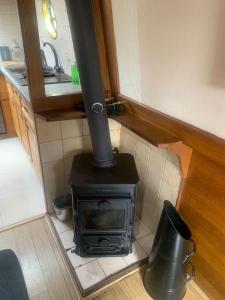 a stove in the corner of a kitchen at Narrowboat stay or Moving Holiday Abingdon On Thames DIFFERENT RATES APPLY ENSURE CORRECT RATE SELECTED in Abingdon