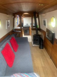 een woonkamer met een bank en een tv en een keuken bij Narrowboat stay or Moving Holiday Abingdon On Thames DIFFERENT RATES APPLY ENSURE CORRECT RATE SELECTED in Abingdon