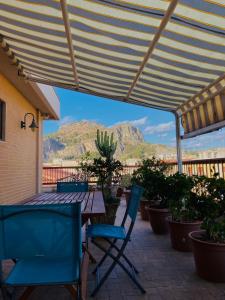 un patio con mesa, sillas y montañas en Casa di Frank: appartamento a due passi dal mare, en Cefalú