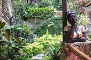 eine Statue einer Frau, die einen Ball in einem Garten hält in der Unterkunft Solar do Cosme in Rio de Janeiro